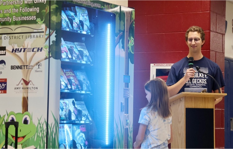 picture of student standing in front of book vending machine 